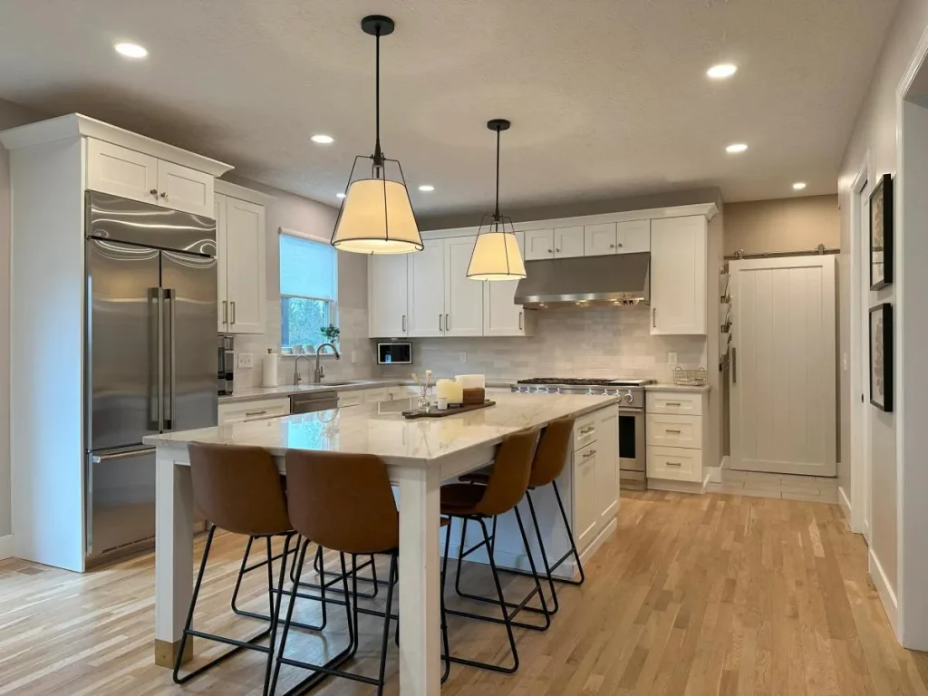 “Classic kitchen with paneled white cabinets, marble backsplash, and brass fixtures.”