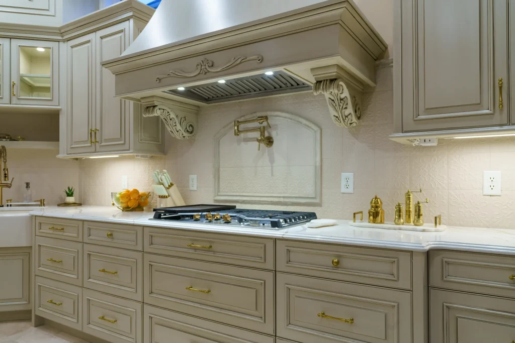 “Classic kitchen with paneled white cabinets, marble backsplash, and brass hardware.”
